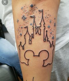 a woman with a disney castle tattoo on her arm