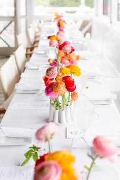 a long table with flowers in vases on it