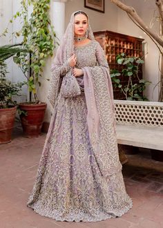 a woman in a purple wedding gown standing on a brick floor with her arms crossed