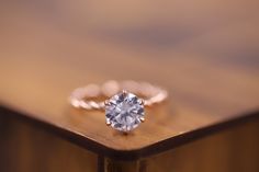 a diamond ring sitting on top of a wooden table