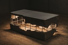 a cage that is sitting on the ground in the middle of an empty room with light coming through it