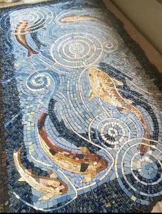 a mosaic floor with fish and waves on it