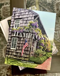 a book sitting on top of a window sill next to a flag and flowers