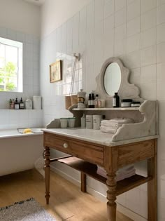 a bathroom with a sink, mirror and bathtub in it's center area