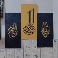 three paintings hanging on the wall with arabic calligraphy written in gold and blue colors