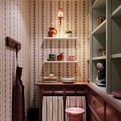 a kitchen with pink and green wallpaper on the walls next to a wooden cabinet