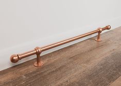 an image of a metal bar on the floor with wood floors and white walls in the background