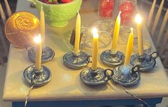 some candles are sitting on a table next to a potted plant and two euro coins