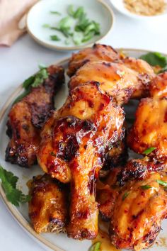 grilled chicken wings on a plate with garnishes