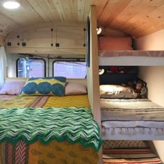 the interior of a camper with bunk beds and pillows on it's sides