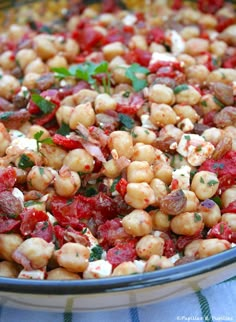 a bowl filled with lots of food on top of a blue and white table cloth