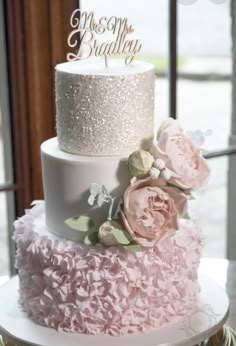 a three tiered wedding cake with pink flowers on top