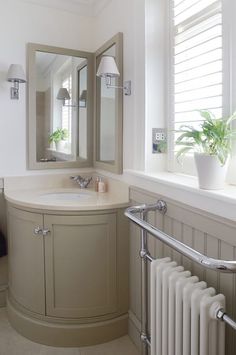 a bathroom with a sink, mirror and radiator