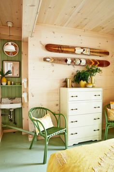 a bedroom with green furniture and surfboards on the wall