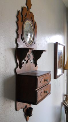 a wooden shelf with two drawers and a mirror on the wall