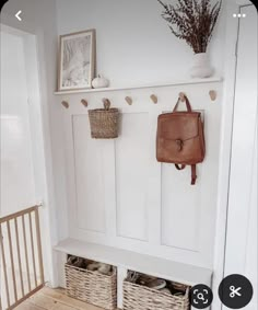 a white coat rack with baskets on it and a purse hanging from the wall next to it