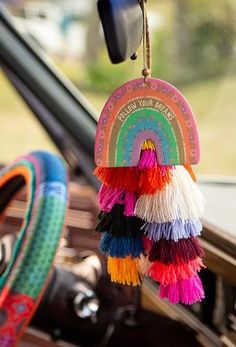 the interior of a car with colorful tassels hanging from it's dashboard