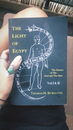 a person holding up a book with an image of the human body on it's cover