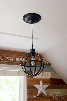 a light fixture hanging from the ceiling in a room with wood paneling and starfish