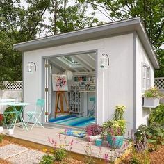 a small white shed sitting in the middle of a yard