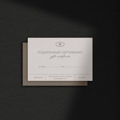 a black and white business card on a dark surface with the words congratulations written in russian