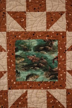 a close up of a quilt with fish on it