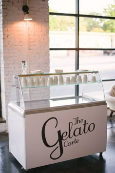 the gelato cart is set up in front of a window