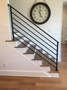 a clock mounted on the wall above a stair case