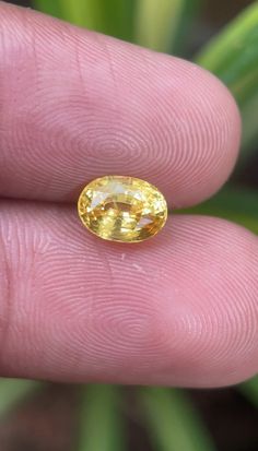 a close up of a person's hand holding a yellow ring