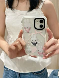 a woman holding up her phone case with some mice on it