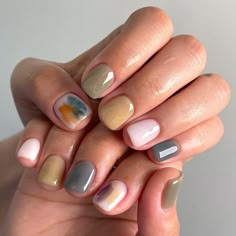 a woman's hands with different colored nails and manies on their fingertipss