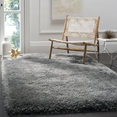 a chair sitting on top of a rug next to a window