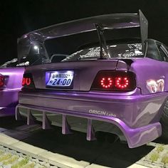 the back end of a purple car with its hood open