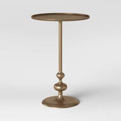 a gold metal table with two balls on the top and one ball at the base