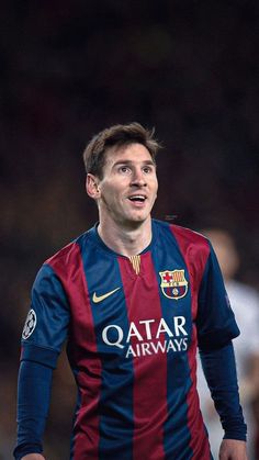 a man in a blue and red shirt is playing soccer