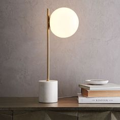 a lamp that is sitting on top of a table next to books and a book