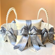 two silver wedding garters with bows and pearls on them, sitting on a table