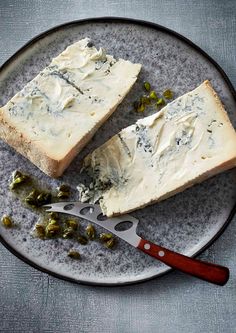 two pieces of cheese on a plate with a knife