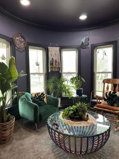 a living room filled with furniture and lots of plants on top of it's coffee table