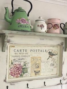 there is a teapot and two cups on the shelf above it, with an old sign