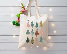 "Personalized Christmas Tote Bag, Cute Christmas Totes, Christmas Gifts, Holiday Totes, Christmas Canvas, Customized Tote Bag, Santa Bag - Bag Size: 14.96\"x 15.75\" - This is a perfect gift for your kids, family, friends, or your beloved ones for hanging out or grocery shopping. - This is a tote bag made from cotton. If you have any questions, please send a message via Etsy Message." Christmas Totes Cricut, Christmas Tote Bags Diy, Diy Christmas Bags, Christmas Totes, Scrunchies Business, Winter Tote Bag, Painted Canvas Bags, Canvas Bag Diy, Holiday Tote Bag