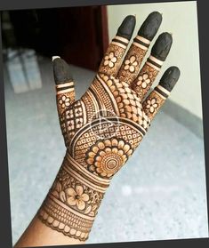 a woman's hand with henna tattoos on it