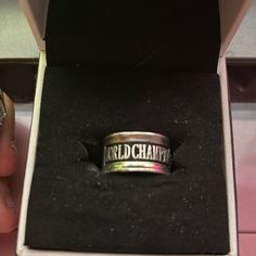 someone is holding a ring that says world champion in the middle of their hand and it's inside an open box