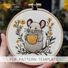 a hand holding a small embroidered mouse with a cup in it's paws and the text, free pattern template