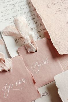 pink and white paper with writing on it, some torn off pieces of paper next to each other