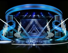 the stage is lit up with blue lights and an abstract design on it's walls