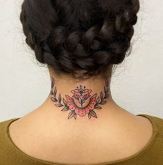 a woman with a tattoo on her neck and behind her head is a braid bun