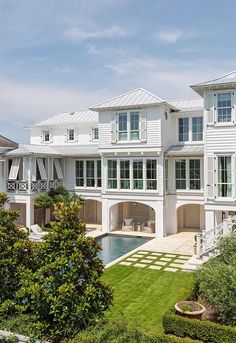 a large white house sitting next to a lush green field