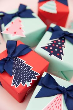 several colorful boxes with bows on them are sitting on a table and one box has a christmas tree on it