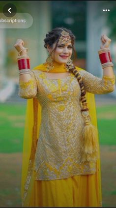 a woman in a yellow outfit holding her hands up